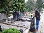 Młodzież z ,,8 Wspaniałych" sprząta grób Seydaków na cmentarzu katolickim